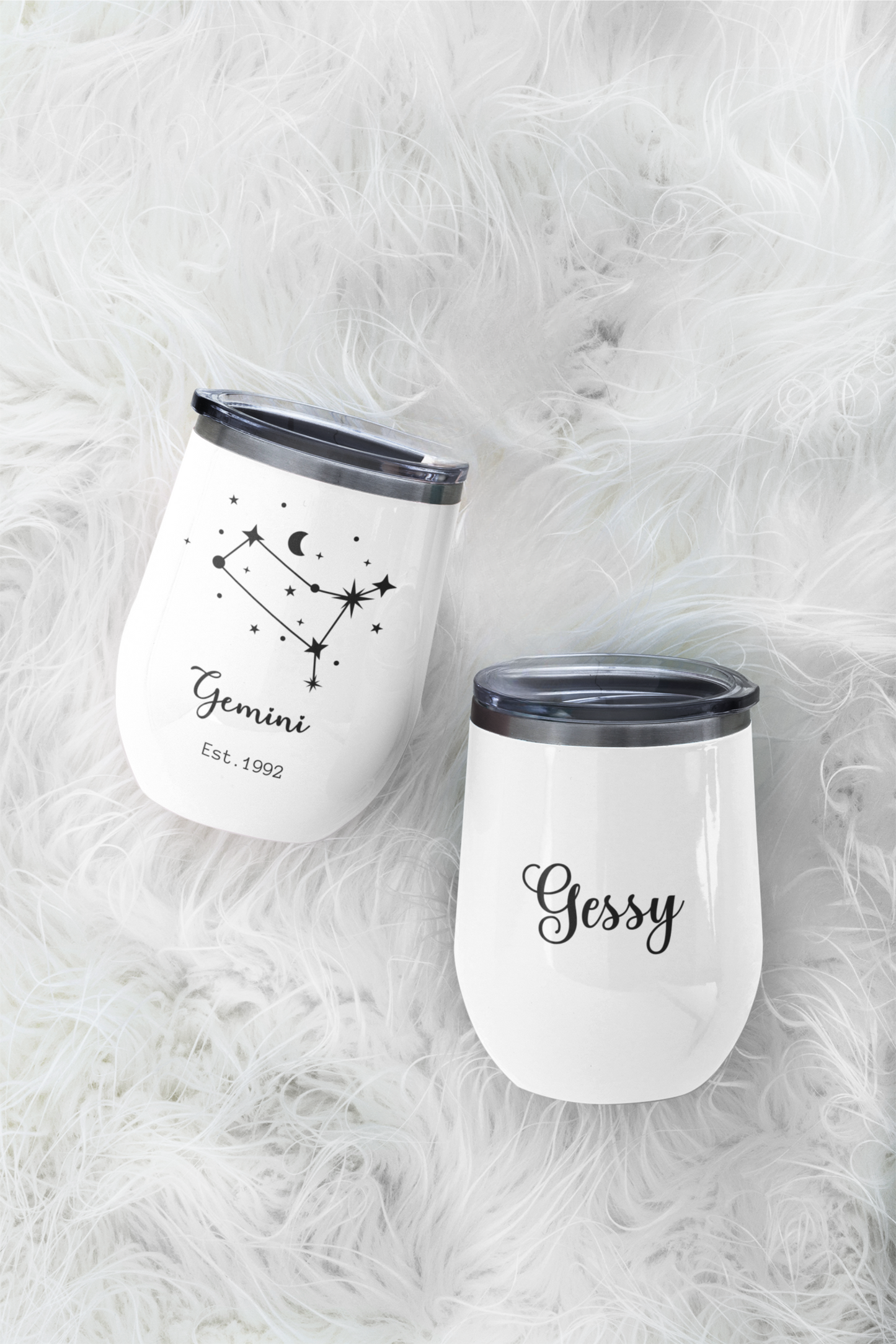 Custom Zodiacal Wine Tumbler - Two white tumblers with black text and designs on a fluffy white surface